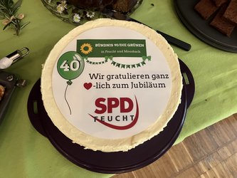 Torte mit Aufdruck. Der Aufdruck zeigt das Logo von Bündnis 90 / DIE GRÜNEN und der SPD. Aufschrift: Wir gratulieren ganz herzlich zum Jubiläum. SPD Feucht und ein grüner Luftballon mit einer 40 
